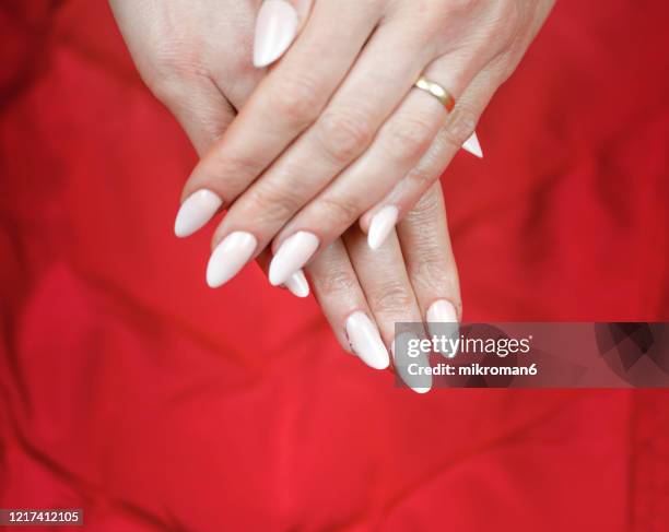 close-up of woman fingers with nail art, nude manicure - white nail polish stockfoto's en -beelden