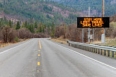Electronic sign along U.S. Highway 97 notifying people to stay home and save lives by reducing the risk of being infected due to COVID-19