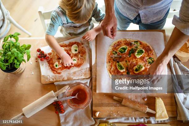 view from above of father with small son making pizza at home, cooking. - preparazione foto e immagini stock