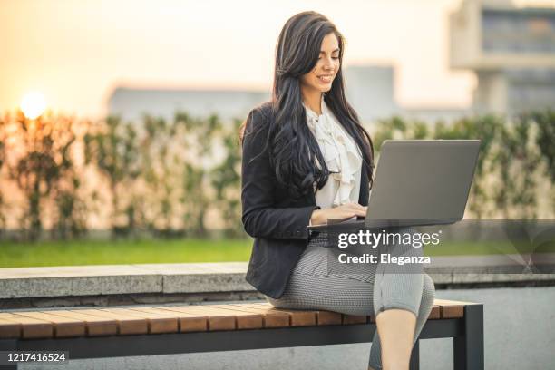 businesswoman using laptop on park bench - bench dedication stock pictures, royalty-free photos & images