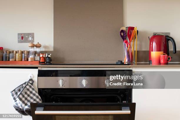 view of a kitchen worktop and oven with spices and utensils - kettle stockfoto's en -beelden