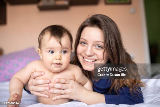 bambino e mamma che giocano sul letto - occhi verdi foto e immagini stock