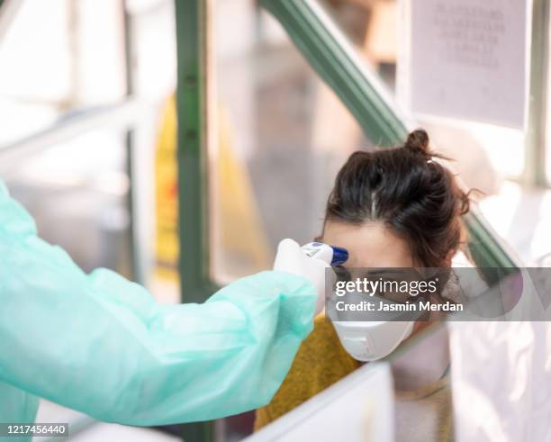 checking body temperature of covid-19 coronavirus treatment in quarantine - ラッサ熱 ストックフォトと画像