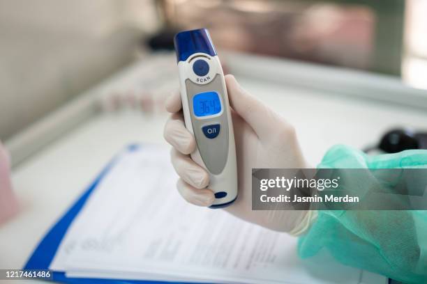 checking body temperature of covid-19 coronavirus treatment in quarantine - ラッサ熱 ストックフォトと画像