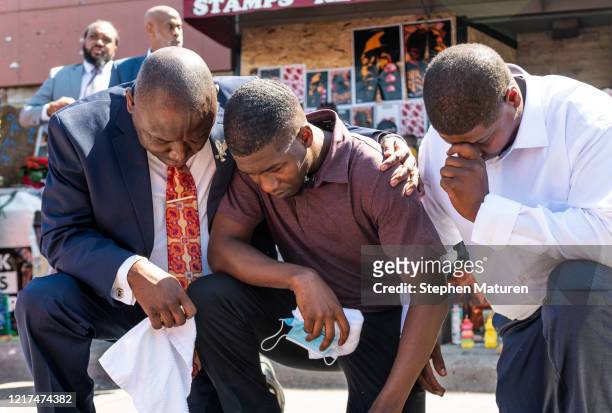 Quincy Mason Floyd , son of George Floyd, and attorney Ben Crump kneel at the site where Floyd was killed on June 3, 2020 in Minneapolis, Minnesota....