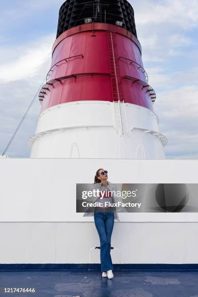 junge frau auf einem kreuzfahrtschiff unter einem trichter - ship funnel stock-fotos und bilder