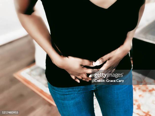 woman suffers pelvic pain from adenomyosis, endometriosis, fibroids or other cause - fibroids stockfoto's en -beelden