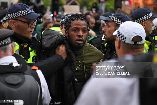 Police officers detain a protestor during an anti-racism demonstration in London, on June 3 after George Floyd, an unarmed black man died after a...