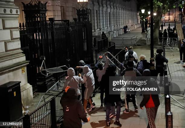 Protestors throw barriers towards the gates of Downing Street during an anti-racism demonstration in London, on June 3 after George Floyd, an unarmed...