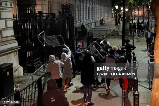 Protestors throw barriers towards the gates of Downing Street during an anti-racism demonstration in London, on June 3 after George Floyd, an unarmed...