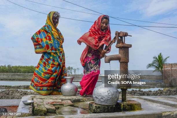 Women are seen collecting drinking water from a local tube-well in the aftermath of the extremely severe cyclonic storm Amphan. Thousands of shrimp...