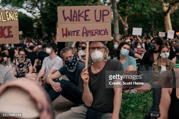 Demonstrators pause for a moment of silence during a protest over the killing of George Floyd by a Minneapolis Police officer, in McCarren Park in...