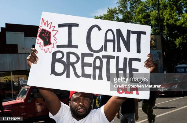 Man holds up a sign stating "I Can't Breathe" at a memorial for George Floyd on June 3, 2020 in Minneapolis, Minnesota. Former police officer Derek...