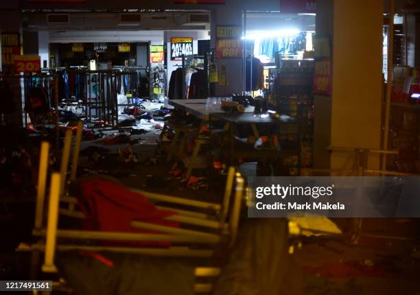 Emergency lights illuminate scattered merchandise strewn across the floor of a looted Modell's sporting goods store in the upscale Rittenhouse...