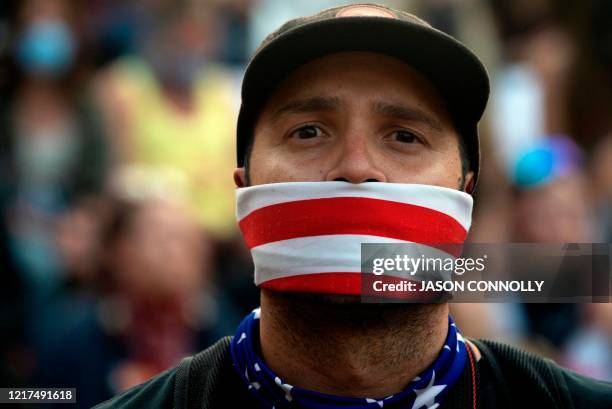 Demonstrator wearing a face mask is seen in Denver, Colorado on June 3 while protesting the death of George Floyd, an unarmed black man who died...