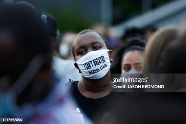 Man attending a vigil wears a mask with the words "I can't breathe" and the name of Manuel Ellis a 33-year-old black man who died in Tacoma Police...