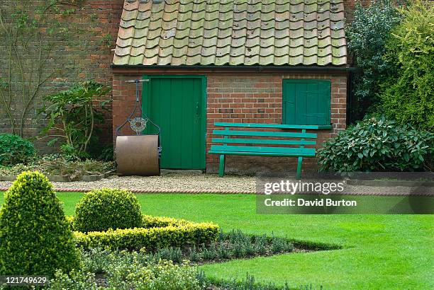 garden view with red brick garden shed and traditional grass roller - boxwood stock pictures, royalty-free photos & images