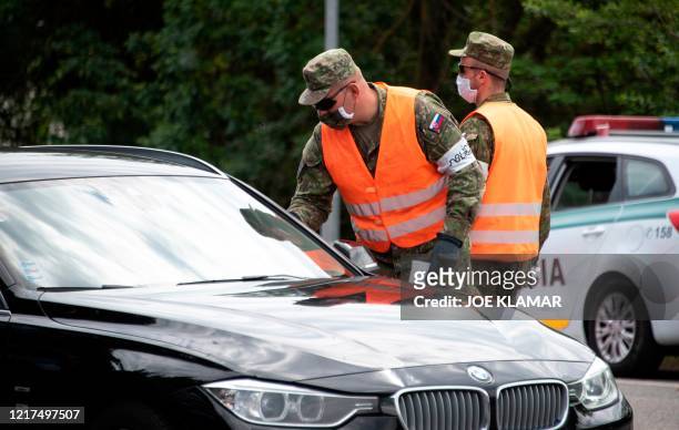 Slovak police officers checks the papers of travelers crossing the Bratislava-Berg border crossing between Austria and Slovakia during the...