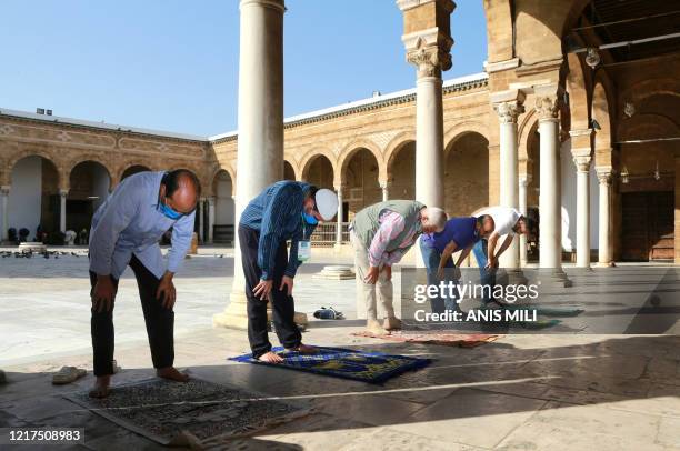 Tunisians gather to pray in the court of Al-Zaytuna mosque, the oldest in the capital Tunis, on June 4 following its reopening after authorities...