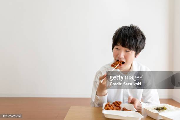 asian businessman working from home enjoying takeaway meal at home - chopsticks stock pictures, royalty-free photos & images