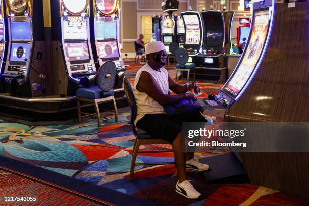 Person wearing a protective mask plays a slot machine at the Bellagio Hotel and Casino in Las Vegas, Nevada, U.S., on Thursday, June 4, 2020. All...