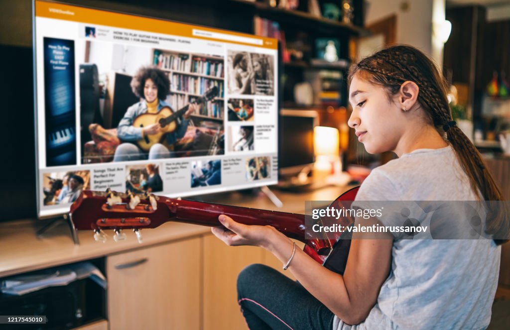 Mädchen spielen eine Gitarre mit Video Online-Telekonferenzen zu Hause in Isolation
