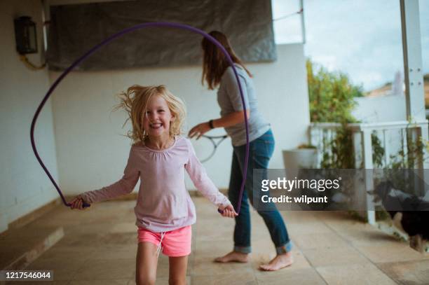 ロックダウン中にママと自宅でロープをスキップフロントビュー - 縄跳びをする ストックフォトと画像