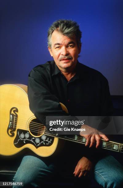 Studio portrait of John Prine posing with a Gibson J-200 acoustic guitar, backstage at Luna Theater, Brussels, Belgium, 28th May 1996.