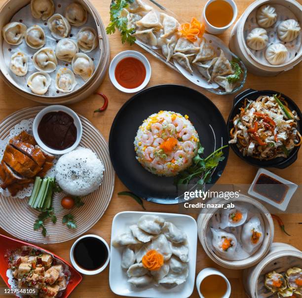 mesa llena de comida china. - raviolis chinos fotografías e imágenes de stock
