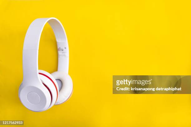 white  headphones on yellow background - headphones isolated foto e immagini stock