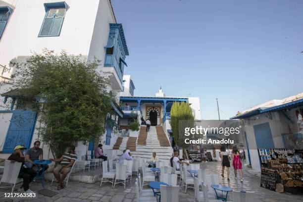 People tour the touristic Sidi Bou Said town, 20 kilometers from Tunisian capital Tunis, after cafes and touristic places reopened following the...