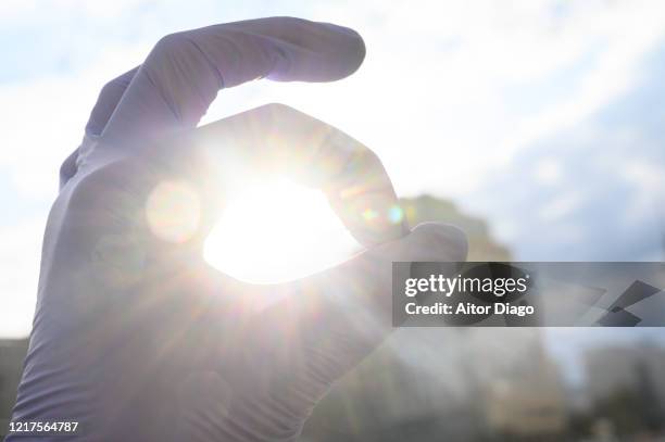 hand with protection globes against the sun doing ok sign. berlin. germany. - social rehabilitation centre stock pictures, royalty-free photos & images