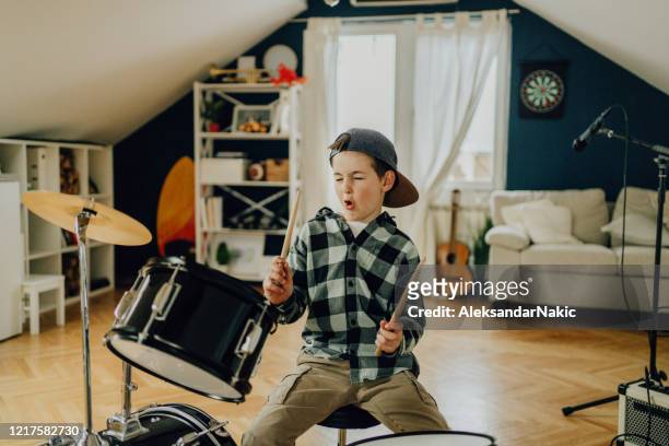 niño pequeño tocando la batería - playing drums fotografías e imágenes de stock