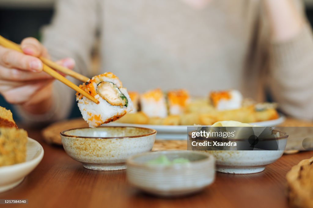 Woman eating sushi rolls