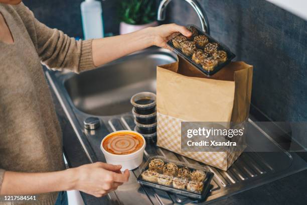 donna che disimballa la consegna di cibo da asporto - soup home foto e immagini stock