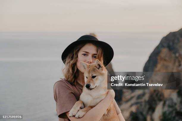 portrait of young woman hugging her dog. shiba inu - cute shiba inu puppies stock pictures, royalty-free photos & images