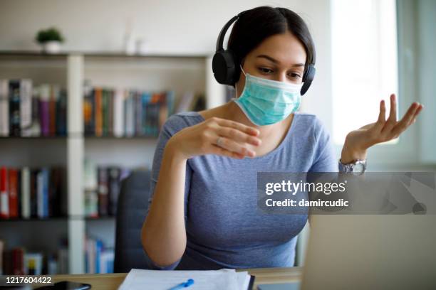 mujer maestra con máscara protectora facial enseñanza en línea desde casa - máscara quirúrgica fotografías e imágenes de stock