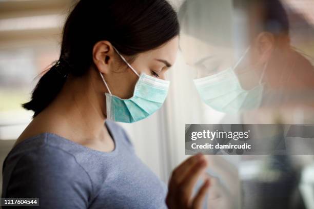 portrait of sad young woman with face protective mask at hospital - covid anxiety stock pictures, royalty-free photos & images