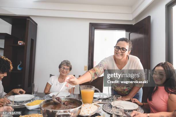 familie mittagessen am esstisch serviert mit feijoada, typisch brasilianischen schwarzen bohnen eintopf - brazilian feijoada dish stock-fotos und bilder