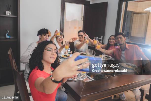 familie macht selfie rund um den esstisch serviert mit feijoada, typisch brasilianischen schwarzen bohnen eintopf - brazilian feijoada dish stock-fotos und bilder