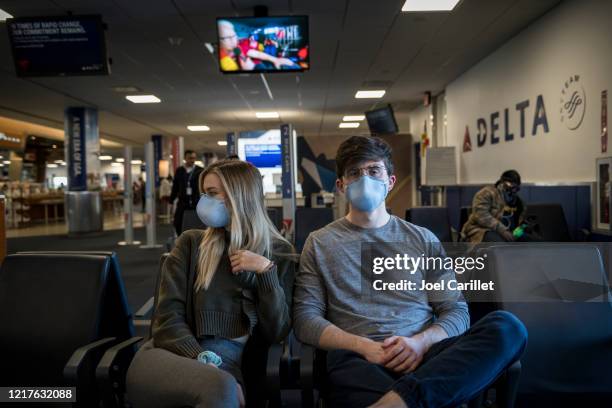 passengers wearing face mask at laguardia airport because of covid-19 pandemic - airport mask stock pictures, royalty-free photos & images