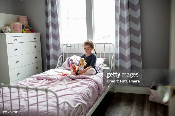 little girl plays on her bed. - doll stock pictures, royalty-free photos & images