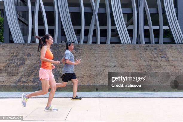 sports team jogging in the city, keeping each other going - hong kong lifestyle society health stock pictures, royalty-free photos & images