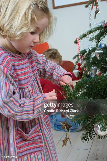 boy and girl hanging christmas decorations - clark bros stock pictures, royalty-free photos & images