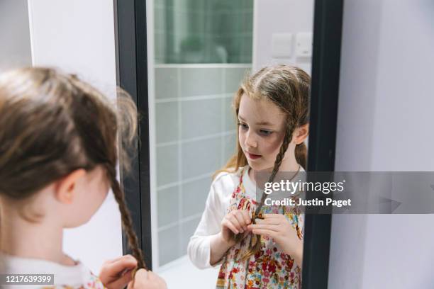 young girl plaiting hair - braided hair photos et images de collection