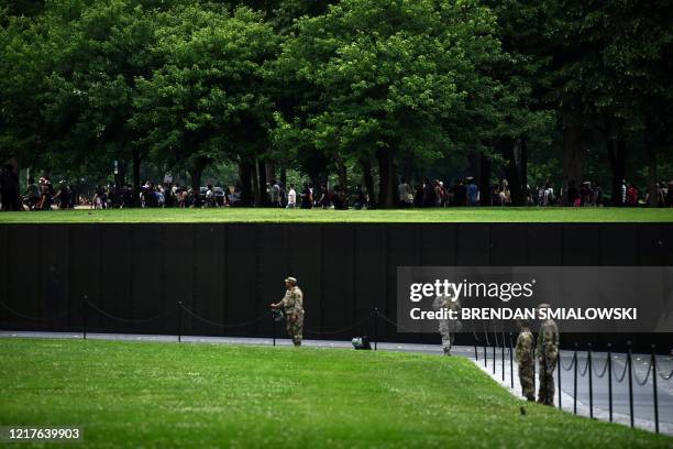 Protestors march by the Vietnam Veterans Memorial at the National Mall during a demonstration over the death of George Floyd, who died in police...