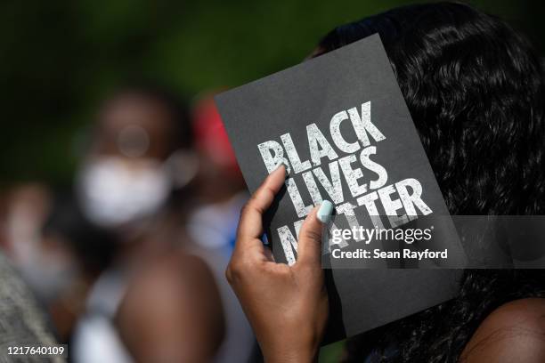 Demonstrator holds a card that reads, Black Lives Matter, outside of the Glynn County courthouse during a court appearance by Gregory and Travis...