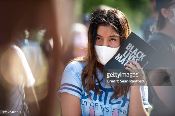 Demonstrator holds a card that reads, Black Lives Matter, outside of the Glynn County courthouse during a court appearance by Gregory and Travis...