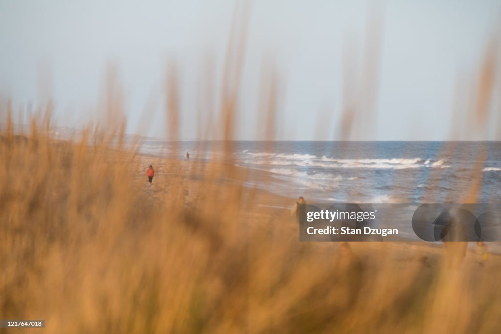 People Walking on Beach for excersize observing social distancing during the Covid-19 Pandemic.