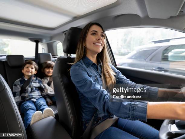 happy mother riding with her kids in the car - car stock pictures, royalty-free photos & images